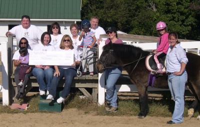 Dr. John Timothy Modic (top left), recently donated $10,000 for the Greenwell Foundation's Therapeutic Riding Program. Also pictured are Executive Director Kendall Sorenson-Clark (behind horse), and Shannon Long, Director, Equestrian Programs (right) along with unnamed horseback riding program participants.