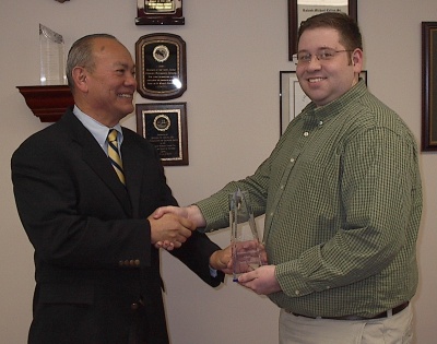 RMC Inc. CEO Michael Colina (left) presents St. Mary's College of Maryland graduate David Hickman with the firm's Employee of the Year award.