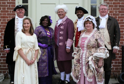 Photographed in front of the old Port Tobacco Courthouse, in full period clothing, are (l. to r.): Commissioner Samuel N. Graves, Jr.; Denise Ferguson, Clerk to the Commissioners, Charles County Government; Commissioner Vice President Edith J. Patterson; Commissioner President Wayne Cooper; Commissioner Reuben B. Collins, II; Joyce Schmidt, Chief of Staff, Charles County Government; and Commissioner Gary V. Hodge. (Photo: George Clarkson)
