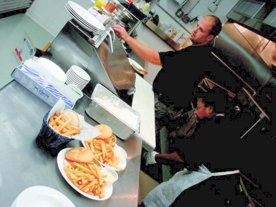 Neal Reilly, head chef at the new Evans Seafood restaurant and Delores Morgan, a veteran of the previous seafood house, get food ready for hungry customers. (Photo: Guy Leonard)