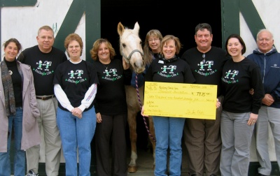 Dr. J. Timothy Modic (third from right), recently donated $7,975 to the Greenwell Foundation's Therapeutic Riding Program. Also pictured are Interim Executive Director Jolanda Campbell (holding "check"), horseback riding program volunteers and members of Dr. Modic's staff. (Submitted photo)