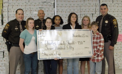 Piccowaxen Middle School students present a check to Officers Colby Shaw, John Long, and Cpl. Holt for $830 to be used for "Shop with a Cop," an outreach program to help local children at Christmas time. (submitted photo)