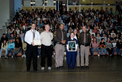 Piccowaxen Middle School students assemble in recognition of their successful fundraising efforts for Special Olympics Maryland. (from left) Piccowaxen Principal Kenneth Schroeck, George Hoehl, Sgt. Gus Proctor, Christine Hoehl (a Special Olympics bronze medalist), Betsy Jiron, and Cpl. Holt. (Submitted photo)