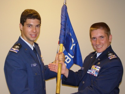 Incoming St. Mary's Civil Air Patrol cadet commander Cadet Major Victor Traven (left) accepts the squadron flag from outgoing cadet commander Cadet Lt. Col. David Trick. (Submitted photo)