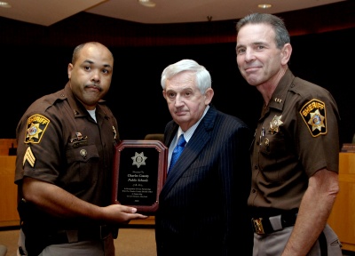 Sgt. Gus Proctor (left), who coordinates the Sheriff’s Office’s Special Olympics fundraisers, and Sheriff Rex Coffey (right) present a plaque to Superintendent James Richmond in honor of the funds raised by the school system for Special Olympics. (Photo: Submitted photo)