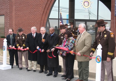 Pictured (left to right) are Charles County Administrator Paul W. Comfort, Major Joseph Montminy, Commissioner Gary V. Hodge, Commissioner President Wayne Cooper, Commissioner Reuben B. Collins, II, Sheriff Rex W. Coffey, Commissioner Vice President Edith J. Patterson, Commissioner Samuel N. Graves, Jr., and Major Buddy Gibson during the ribbon cutting in Waldorf on January 13.