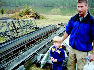 Richard Johnson, of Valley Lee, stands with his son Russell next to parts to build his wind turbine. The state’s critical area commission recently said he could proceed after initially expressing concerns over the project. (Photo: Guy Leonard)