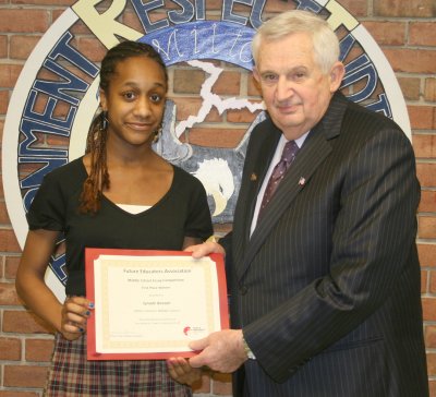 Charles County Public Schools Superintendent of Schools James E. Richmond, right, presents Milton M. Somers Middle School eighth grader Synade Beason, left, with a first place Future Educators Association Writing Prompt Essay Competition award on Friday, March 12. Beason won the national award for her essay, which discussed technological advances and their implications on the teaching profession. (Submitted photo)