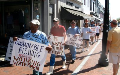 Dozens of watermen and their families march up Main Street in Annapolis on their way to the State House. The group was demonstrating in support of a bill that would give stiffer penalties to poachers and delay the implementation of oyster sanctuaries. (Photo: Brady Holt)