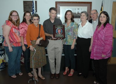 Pictured are Judy Walker, Tamara McClanahan, Hilda McClanahan, John McClanahan, Shannon Mayforth, Caroline Domingue, Jean Domingue and Ann Buccheri. John McClanahan holds a plaque honoring Suzanne McClanahan, a former employee who passed in 2009 from colon cancer.