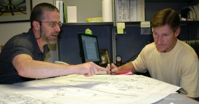 NSWC Dahlgren Division engineers David Sadler (left) and Rob Heflin review a blueprint while discussing ordnance handling routes throughout a Navy warship where safety is crucial in the transportation and storage of ordnance. Sadler and Heflin were recognized with the 2010 Secretary of the Navy Safety Excellence Award for their work to make the Weapon System Explosives Safety Review Board (WSESRB) an emerging center of excellence. WSESRB is the Chief of Naval Operations' independent oversight for safety compliance of all Navy munitions. The board has demonstrated exceptional success over the years in indentifying, mitigating and eliminating safety hazards throughout the development lifecycle of Navy weapons and combat systems. (Submitted photo)