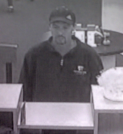 This bank surveillance camera capture shows the suspect standing at the teller window.