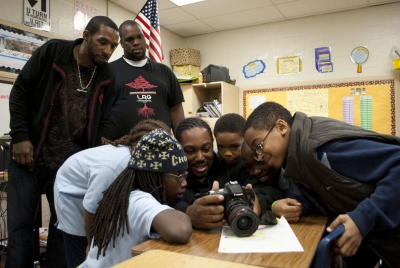 Students gather around Jamal Spratley to watch a short video they made during a session with Spratley, Johnson (top left), and social worker Korey Brady (top right). (Photo: Tami Le)