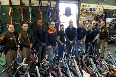 Pictured from left to right: PFC Colby Shaw; PFC Jared Cooney; Wesley Meridith, Charles Sidwell, Mike Cordova, Nick Tesi, Benny Budd, Theresa Richardson, Chris Richardson and Cpl. Don Kabala pause for a photograph before continuing to prepare for their special delivery of new bicycles.