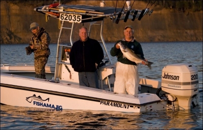 A file photo of Captain Dennis Fleming (far right holding fish) and his boat. The two other men are friends.