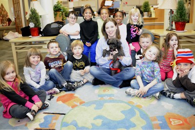 Stacy Cage, director of humane education at the Charles County Humane Society, and students at the St. Charles Children’s Learning Center gather for a photo with “Deuce,” a dog new to the Humane Society and looking for her permanent home. (Submitted photo)