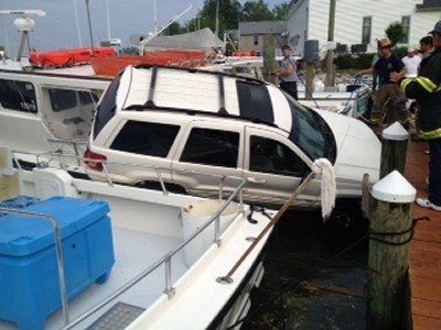 A 70-year-old Chestertown man's Jeep ended up on top of two docked boats after he hit a parked F250 truck, parking posts, and the pier. Police determined the man put the vehicle into reverse by mistake. (Photo courtesy Calvert Co. Sheriff's Office)