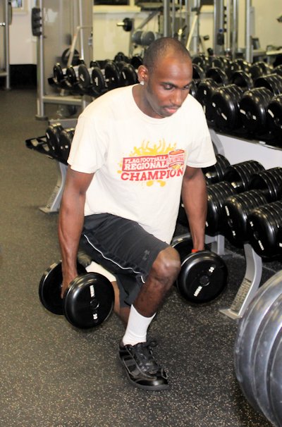 Athlete Larry Mills works with free weights at the Medically Oriented Gym.