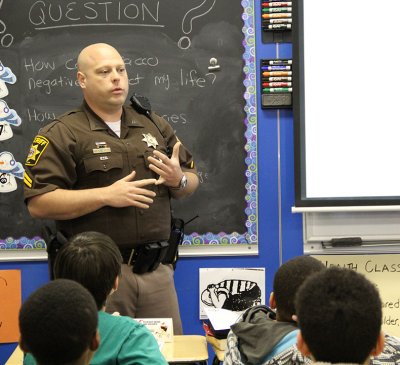 Cpl. Bill Welch, the school resource officer at John Hanson Middle School, teaches a DARE class to students during an April 25 school system visit by officials from the Department of Justice.