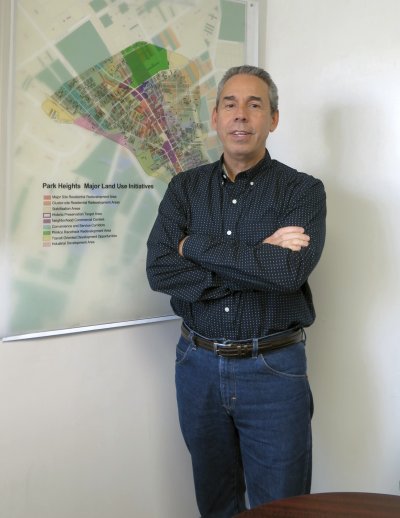 Julius Colon stands in front of a map of Park Heights in his office at Park Heights Renaissance. (Photo: Sam Schmieder)