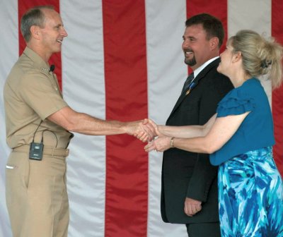 DAHLGREN, Va. (Sept. 4, 2014) - Chief of Naval Operations (CNO) Adm. Jonathan Greenert congratulates Naval Surface Warfare Center Dahlgren Division (NSWCDD) Chief Engineer Dr. James Moreland on his Distinguished Civilian Service Award and thanks his wife, Angela Moreland, for her support during an all-hands call with Sailors, civilians and family members to discuss the current and future status of the Navy. The CNO recognized Moreland's efforts to transform the Navy with a new mission engineering process that resolves critical integration and interoperability issues. (U.S. Navy photo by Chief Mass Communication Specialist Peter D. Lawlor/Released)