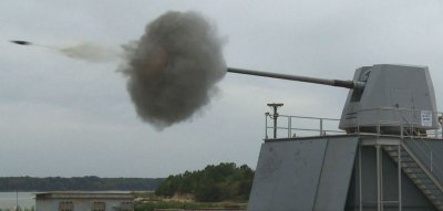 DAHLGREN, Va. - An MK45 5-inch lightweight gun fires on a fictitious threat on the Potomac River Test Range during a surface warfare integration test Sept. 29. Naval Surface Warfare Center Dahlgren Division (NSWCDD) engineers relied on unmanned surface and air vehicles to guide live gun fire onto distant targets, demonstrating a new integrated surface warfare capability in a maritime environment. (U.S. Navy photo by Patrick Dunn/Released)