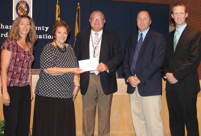 Representatives from Southern Maryland Electric Cooperative (SMECO) presented a $272,000 incentive check to the Board of Education Aug. 11 for energy savings features at St. Charles High School. Presenting the check for SMECO were Jennifer Raley, left, and Jeff Shaw, second from right. Board Chairman Virginia McGraw, second from left, accepted the check on behalf of the Board along with Keith Hettel, CCPS assistant superintendent of supporting services, center, and St. Charles Principal Rick Conley, right.