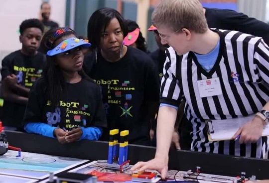 RICHMOND, Va. -- Naval Surface Warfare Center Dahlgren Division (NSWCDD) engineer Serita Seright, 2nd from right, and a student, listen to a judge explain the FIRST LEGO League (FLL) competition rules and point system at Maggie Walker Governor High School in November 2015. Seright&mdash;who mentors a FLL student team called the "Robot Engineers"&mdash;was honored by the National Society of Black Engineers (NSBE) as the Region II "Professionals Member of the Year" for leadership impacting its mission in Virginia, NSWCDD announced, May 16. "I'm humbled to be recognized for personifying the NSBE mission&mdash;to increase the number of culturally responsible black engineers who excel academically, succeed professionally, and positively impact the community," said Seright, in response to the news. The award recognizes individuals who make outstanding contributions to NSBE, especially their chapter and region, in the areas of leadership, excellence, service, and advancement of its programs and mission.