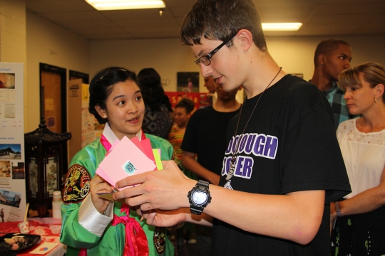 Maurice J. McDonough High School sophomore Eunyeong Joo, left, is a native of South Korea. During the International Festival she talked to Denver Bennett, a sophomore, about her home country's traditions and cuisine. Students had their "passports" stamped as they visited different stations during the fair.