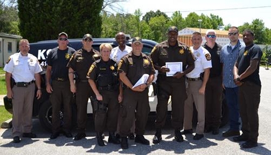 From left to right: Capt. Dan Gimler, Cpl. Sean Brown, Sgt. Haven Smith, Cpl. Renee Cuyler, Sheriff Troy Berry, PFC Colby Shaw, PFC Byron Clark, Maj. Chris Becker, Mr. William Cotton, PFC Darin Behm, and PFC Kevin Makle.