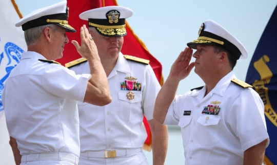 Rear Adm. Tom Druggan, right, commander, Naval Surface Warfare Center, salutes Vice Adm. Thomas Moore, commander, Naval Sea Systems Command, during a change of command ceremony. Druggan relieved Rear Adm. Lorin Selby, center, as NSWC commander at the first change of command ceremony held on the NSWC Dahlgren Division Potomac River Test Range gunline. NSWC comprises eight divisions that operate the Navy's full spectrum research, development, test and evaluation, engineering, and fleet support centers for offensive and defensive systems associated with surface warfare and related areas of joint, homeland and national defense systems from the sea. (U.S. Navy photo by Ryan DeShazo/Released)