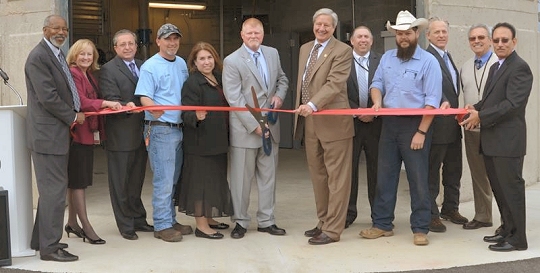 Pictured here during the ribbon cutting ceremony are Deputy County Administrator Wilson Parran, County Administrator Terry Shannon, Senior Project Manager of Dewberry Consultants Reza Emtiaz, Water & Sewer Division Plant Supervisor Christopher Hall, Department of Public Works Deputy Director Enterprise Funds Julie Paluda, Commissioner President Tom Hejl, Commissioner Vice President Evan K. Slaughenhoupt Jr., Commissioner Mike Hart, Water & Sewer Division Operations Superintendent James Ritter, Commissioner Steven R. Weems, Water & Sewer Division Chief Wayne Raither and Department of Public Works Director Rai Sharma. (Photo: Calvert Co. Gov.)