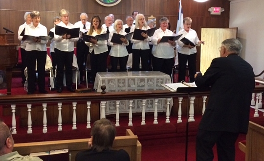 The group's final performance at Union Church in North Beach on November 6, 2016. Participants are as follows: Front row: (left to right) Lea Listzwan, Dee Koskie, Vivian Wright, Sylvia Keyser, Helen Mary Ball, Linda Thompson, Theresa Chambers. Middle Row: (left to right) Bill Goodwin, John Petralia, Doris Brown, Majetta Chase. Back Row: (left to right) Chrys Hill, Joyce Barony, John Bowman, Julian Ball, Paul Shippert. Directing: Larry Brown. Not Shown: Allan Evans and Pianist: Nadine Garrett. Photo by: John Riedesel.