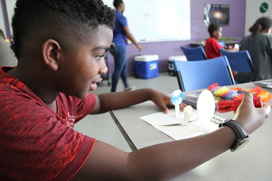 Jayden White, a fifth grader at Berry Elementary School, tests out his project during Fun in the Sun camp at the James E. Richmond Science Center.
