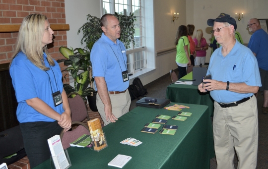 SMECO employees Stacey Hill and Jeff Shaw discuss energy efficiency with a customer-member at the SMECO Annual Meeting held August 23, 2017, at Middleton Hall in Waldorf.