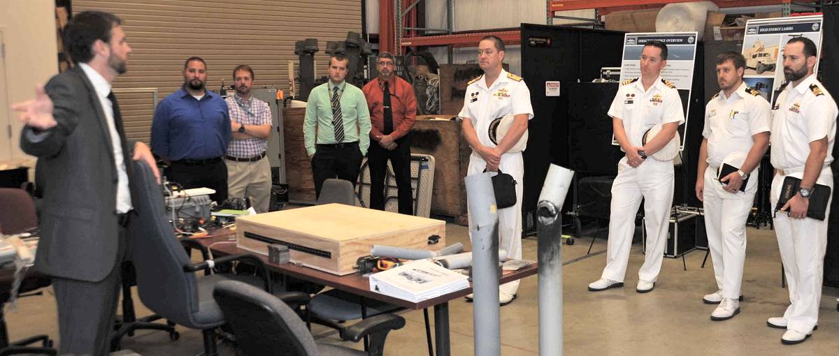 DAHLGREN, Va. (Aug. 16, 2018) – Dr. Chris Lloyd, High Energy Laser Lethality Lead at Naval Surface Warfare Center Dahlgren Division (NSWCDD), briefs Royal Australian Navy (RAN) Commodore Peter Leavy and his delegation at the NSWCDD Laser Lethality Lab during the RAN delegation's NSWCDD visit. Lloyd explained the importance of rigorous modeling and laboratory testing against target materials to ensure high energy laser systems are built that meet the requirements of the warfighter once fielded. NSWCDD is drawing on its knowledge of electromagnetic launchers, hypervelocity projectiles, and directed energy weapons, in addition to its established core capabilities in complex warfare systems development and integration to incorporate electric weapons technology into existing and future fighting forces and platforms. (Photo by U.S. Navy/Released)