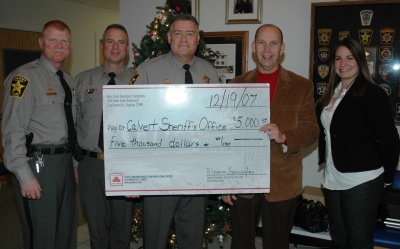 Lt. Col. Tom Hejl, First Sgt. Bill Soper, and Sheriff Mike Evans receive a ceremonial $5,000 check from State Farm Insurance agent Wayne Shoemaker and Emily Presa. The money will be used for child safety programs in Calvert.
