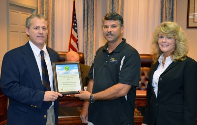 Calvert County Commissioner Steve Weems, left, presents the 2011 Sustainable Business of the Year Award to Wayne and Karen Tabor of AQC Inc.