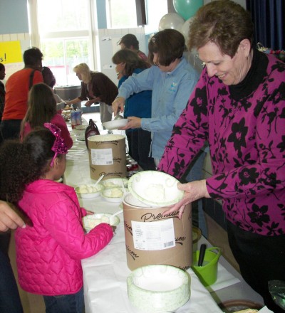 William B. Wade Elementary School Principal Virginia McGraw, right, assists members of the Wade Parent-Teacher-Organization (PTO) in serving ice cream during a book swap/ice cream social held last month to promote reading.