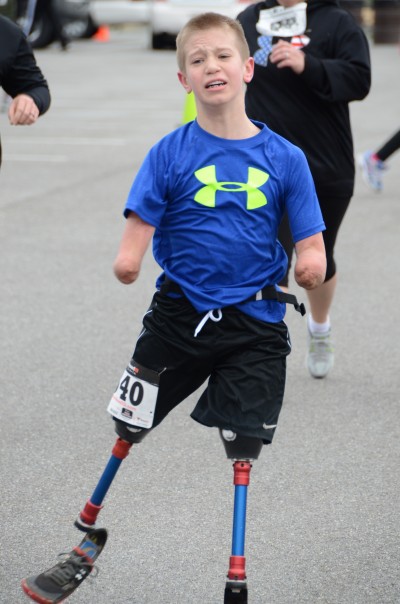 A young runner, Dayton Webber, crosses the finish line. Photo courtesy Det. J. Elliott/Fraternal Order of Police Lodge 24.