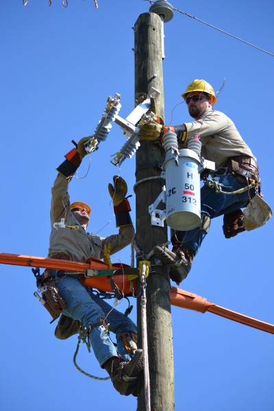 SMECO journeyman linemen Brent Hancock and Daniel Hutchins change a switch atop a utility pole during the Gaff 'n' Go Lineman's Rodeo.