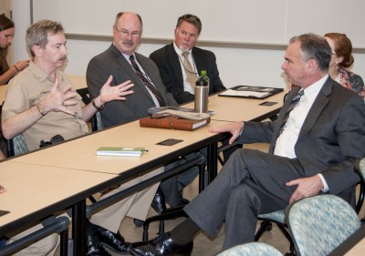 Capt. Michael Smith, Commander Naval Surface Warfare Center Dahlgren Division (NSWCDD), explains the capabilities of the range at Naval Support Facility (NSF) Dahlgren to Senator Tim Kaine. The Virginia senator received a command overview and toured several facilities including the main range, the directed energy facility and the Aegis Training and Readiness Center. Kaine serves on the Senate Armed Services Committee. (U.S. Navy photo by Elliott Fabrizio/Released)