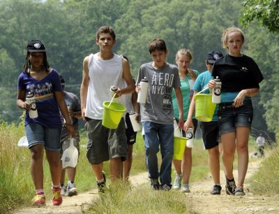 As members of the CSM Kids’ and Teen College “Summer Serve” community service program, Southern Maryland teens came together in a team effort to better the community on June 27. Jacob Middleton-Day, second from left, leads a group of fellow “Summer Serve” volunteers as they take a hydration break from the searing heat. Equipped with bug spray and sunscreen, volunteers embrace the opportunity to lend a helping hand. Teens spent the day pouring buckets of gravel to fill potholes, removing weeds from flowerbeds and carrying lumber as they built new friendships while making a positive difference. The program was founded in 2006 and runs over the course of one week each summer. Pictured with Middleton-Day, from left, are Bianca Wheeler, Michael Fialkowski and Gabrielle Deen.