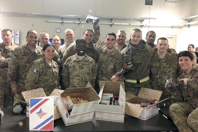 U.S. Air Force men and women serving at Bagram Airfield in Afghanistan pose with the care packages they received from CSM Phi Theta Kappa Honor Society.