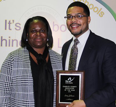 Norma Dallas from the Arc of Southern Maryland, pictured left, presents Larry Johnson, an instructional specialist with Charles County Public Schools, pictured right, with the 2014 Arc of Southern Maryland Charles County Educator of the Year award during the employee recognition portion of the Board of Education’s Jan. 13 meeting.