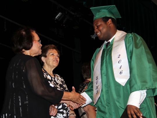 Derrick Johnson, a 2016 graduate of St. Charles High School, is congratulated by board member Margaret Marshall, left, and Board Chairman Virginia McGraw.