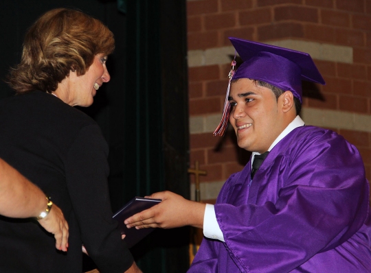 Jose Cruz, a Maurice J. McDonough High School graduate in the SAIL program, receives his diploma from Amy Hollstein, deputy superintendent of Charles County Public Schools.