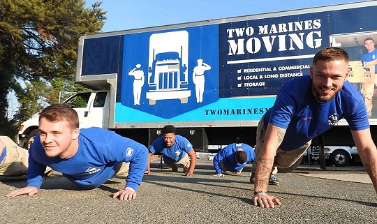 Some of the Two Marines Moving staff perform morning Physical Training (PT) with one of their moving vans in the background. Company founder, Nick Baucom, a U.S. Marine veteran is seen front-left.