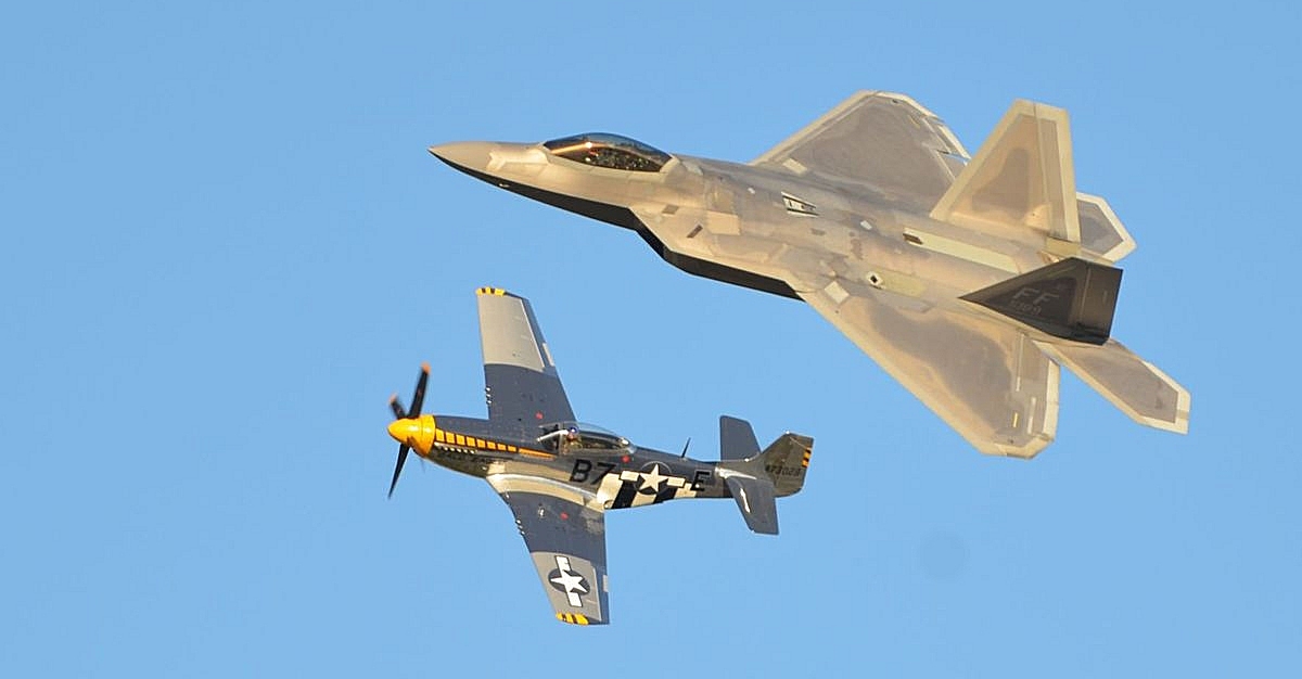 The U.S. Air Force F-22 Raptor demonstration team and World War II-era P-51 Mustang from USAF Heritage Flight fly together in honor of all service members, past and present, at the air expo last weekend. (U.S. Navy Photo by Donna Cipolloni)