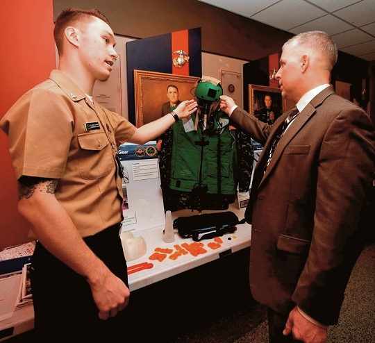 ARLINGTON, Va. (March 15, 2017) - Aviation Electronics Technician 2nd Class Jared Schinse, left, assigned to Fleet Replacement Center (FRC) Mid-Atlantic in Patuxent River, Md., discusses innovative 3D printing solutions and cost reduction plans to manufacture flight deck gear during the Department of the Navy's 2017 3D Print-a-Thon expo at the Pentagon. Twenty DoN organizations - including scientists and engineers from the Naval Research and Development Establishment, maintenance operations, and Marines and Sailors from multiple commands - presented items produced through the use of Additive Manufacturing technology. Naval Surface Warfare Center Dahlgren Division coordinated the event, sponsored by the Deputy Assistant Secretary of the Navy for Research, Development, Test and Evaluation. (U.S. Navy photo by Mass Communication Specialist 2nd Class Alex L. Smedegard/Released)